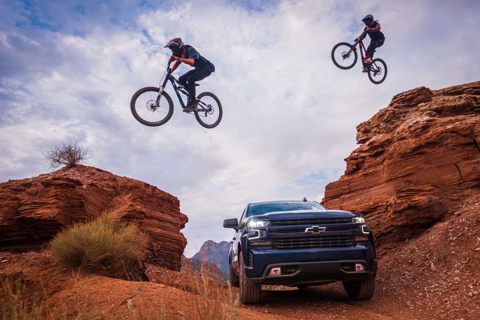 mountain bikes jumping over Chevy pickup