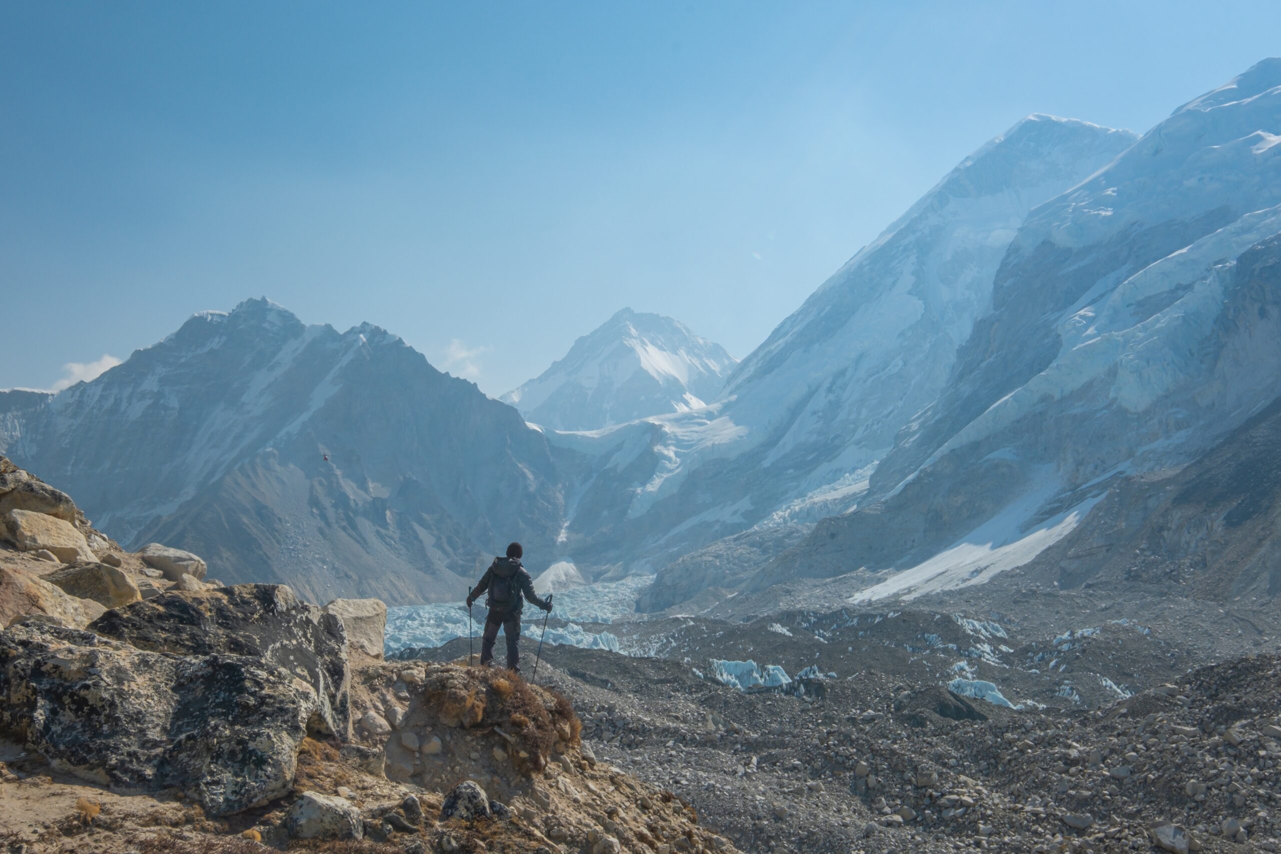 Person hiking the Everest Base Camp trail route, enjoying a view of the Himalayas